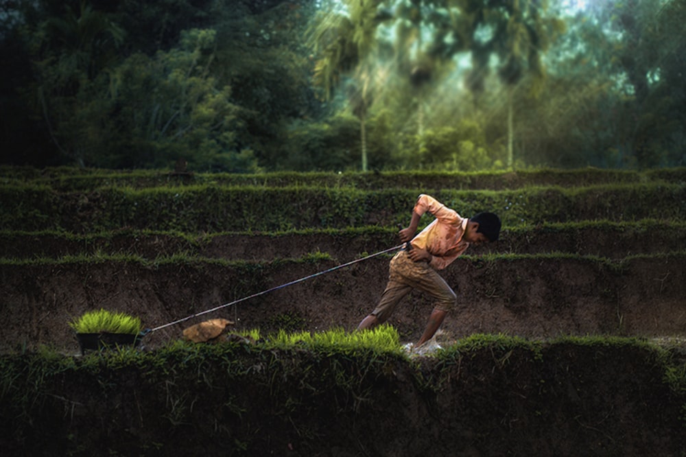 a man pulling a dog on a leash through a maze