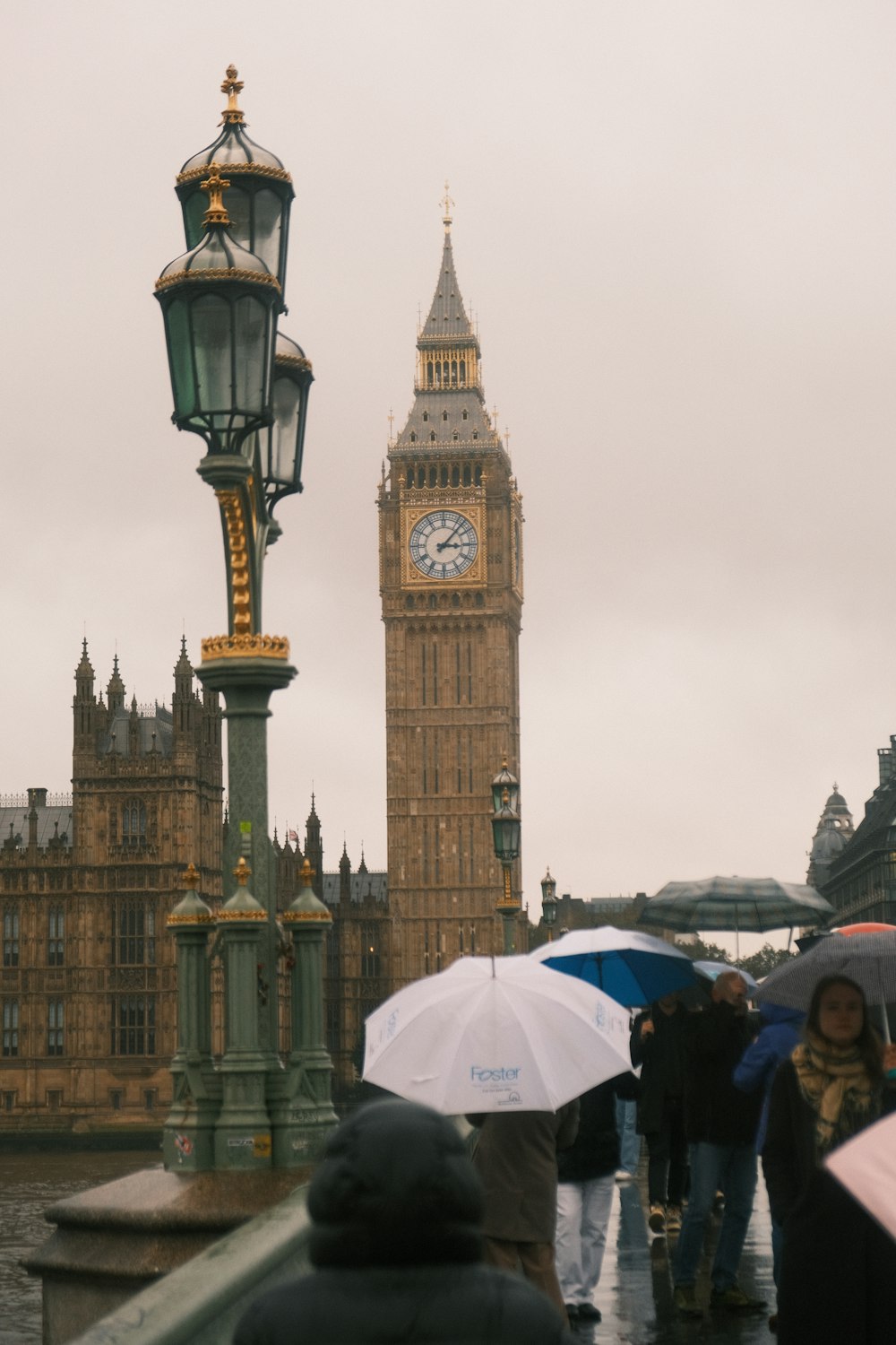 a group of people walking across a bridge with umbrellas