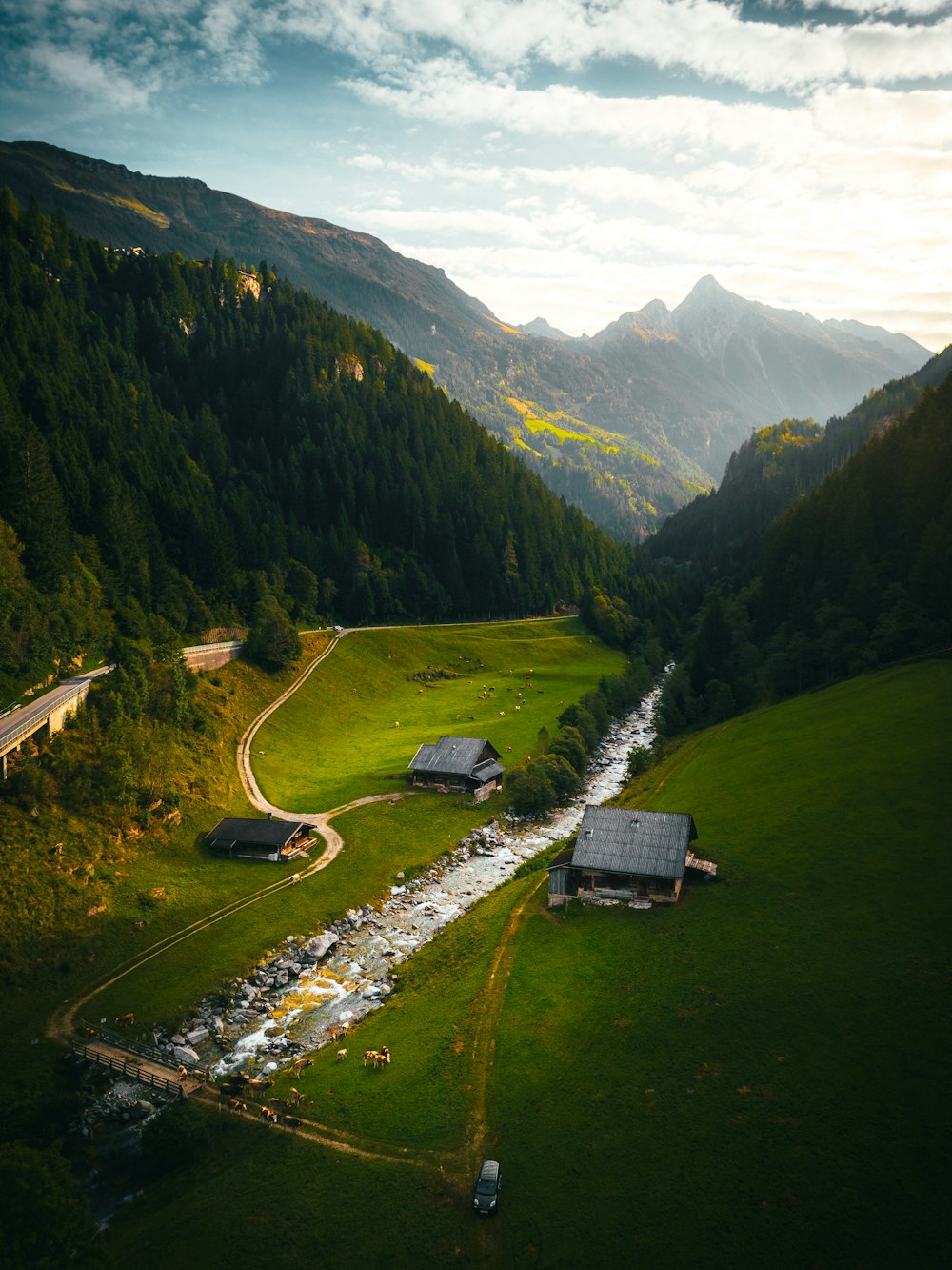 an aerial view of a valley with a stream running through it