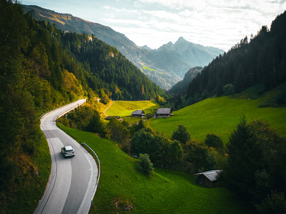 a car driving down a winding road in the mountains