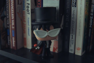 A tiny robot in a tuxedo shaking its butt while holding a champagne glass.