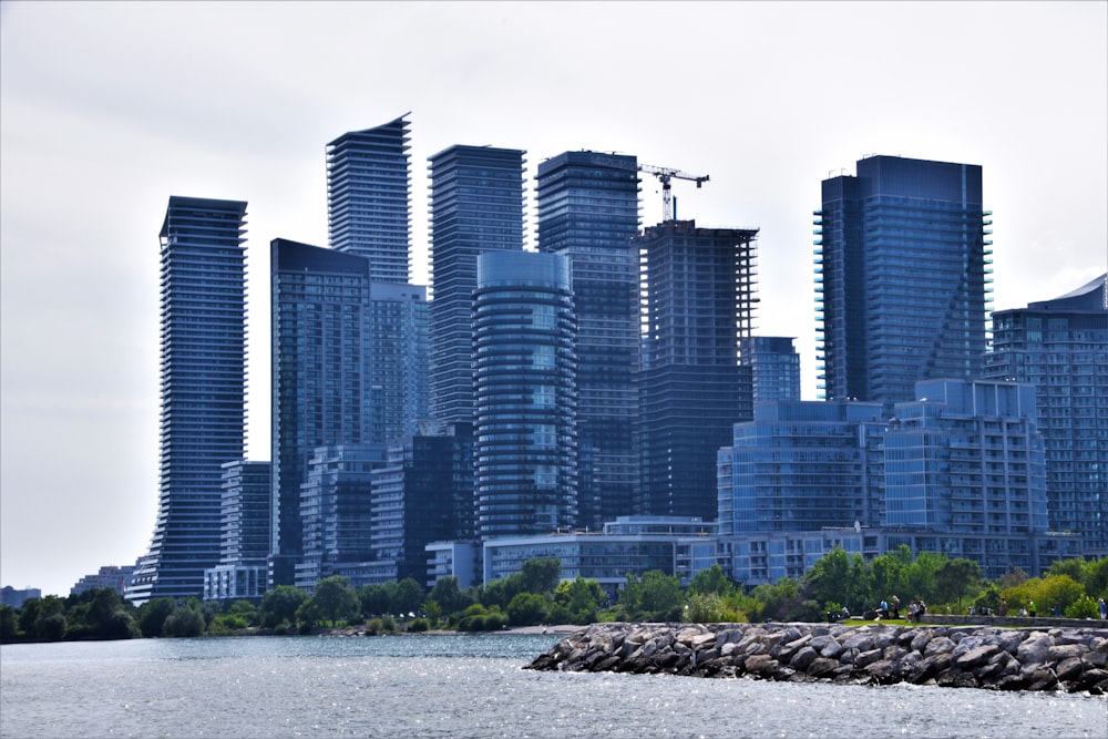 a group of tall buildings next to a body of water