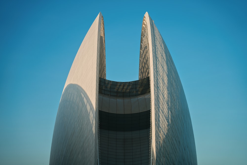 a tall building with a curved roof against a blue sky