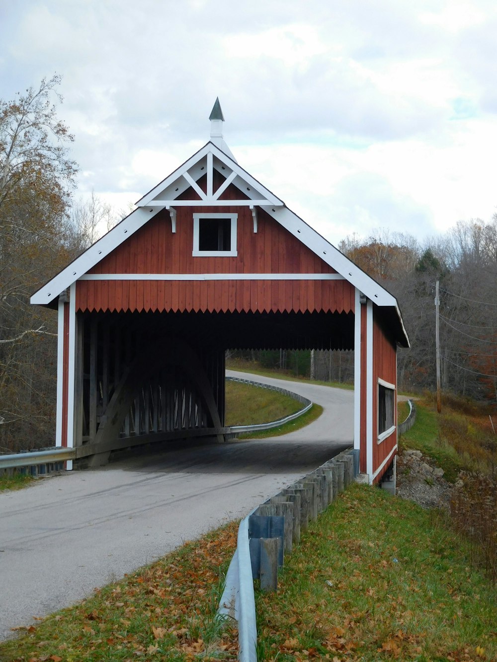 a red and white covered bridge on a country road