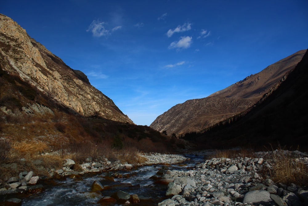 a river running through a valley surrounded by mountains