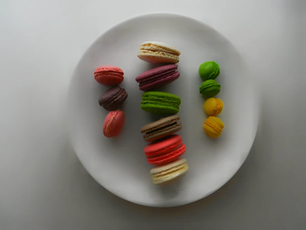 Colorful macarons neatly arranged on a white vintage plate.