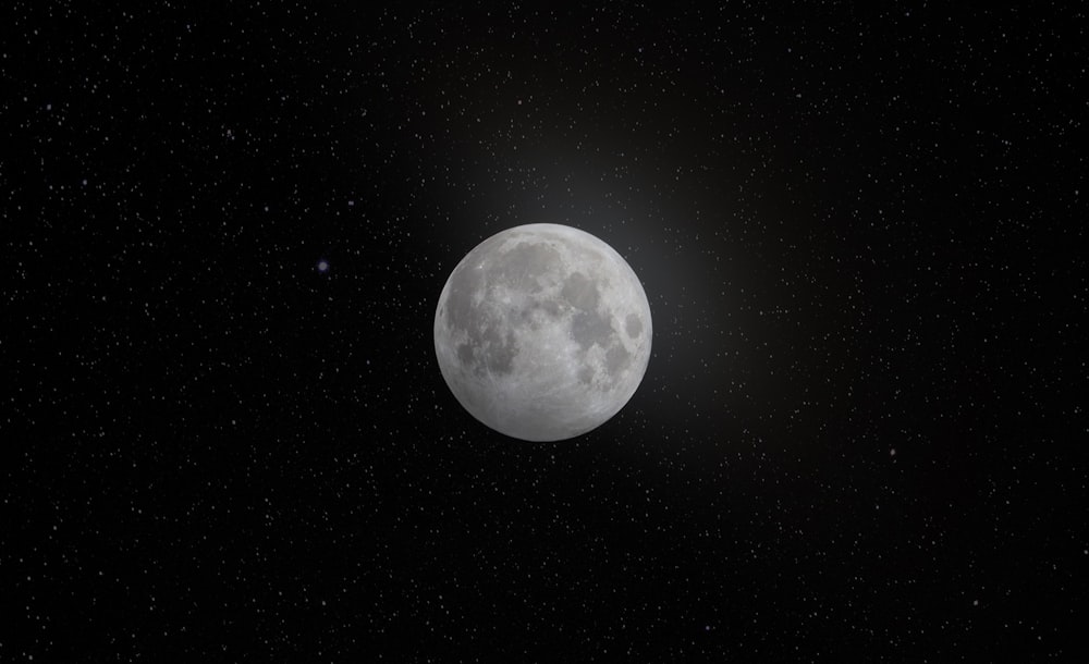 a full moon in the dark sky with stars