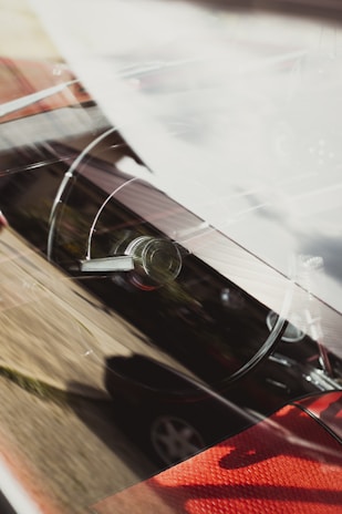 A close-up of a shiny car dashboard with Senegalese scenery reflected in the windshield.