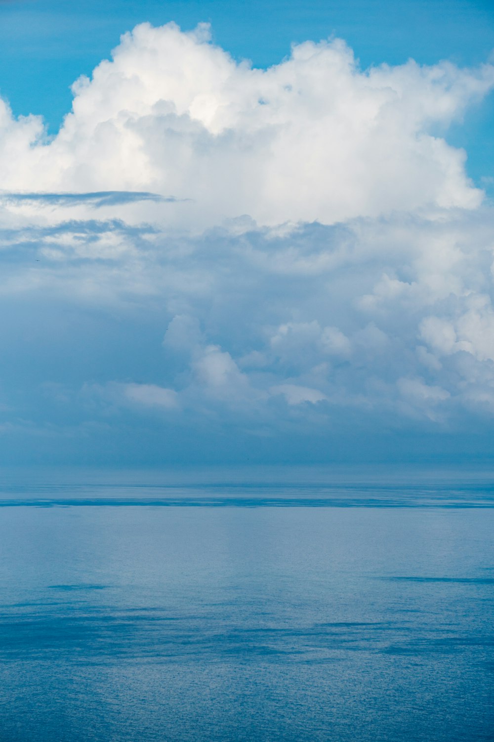 un grande specchio d'acqua sotto un cielo azzurro nuvoloso