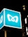 A large, illuminated outdoor sign featuring a stylized logo resembling the letter 'M' is prominently displayed against a dark night sky. The sign is bright and stands out due to its blue background and white logo. The setting appears to be urban, with parts of a building and additional lighting visible.