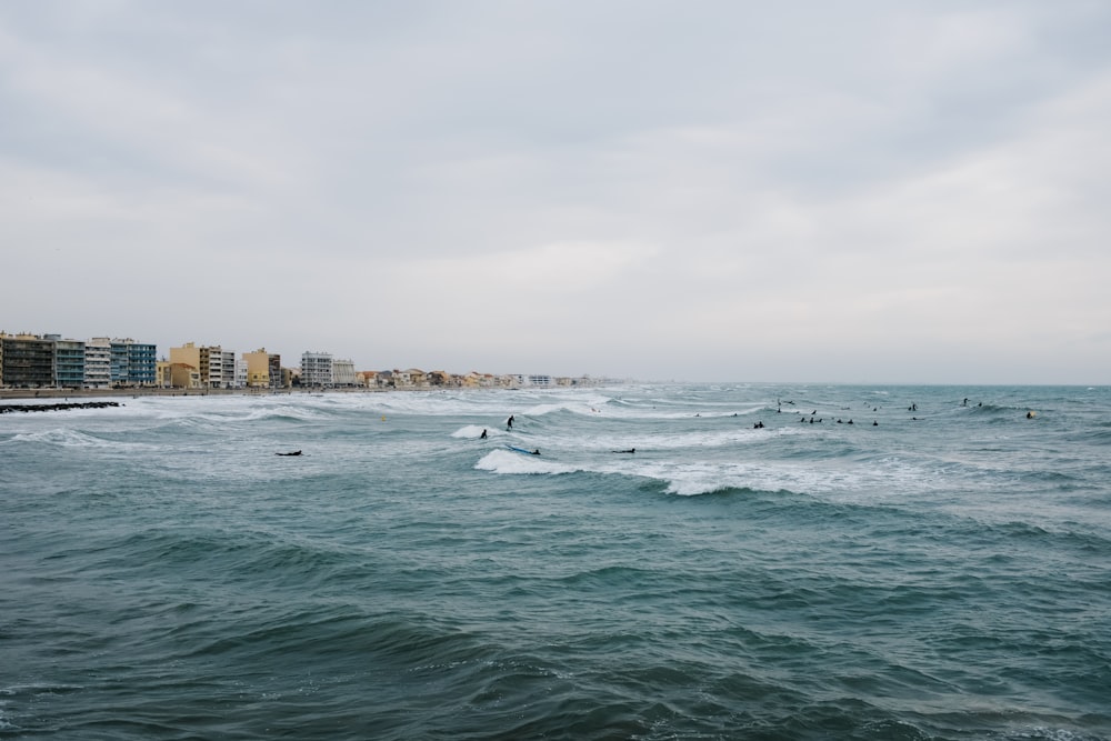 a group of people riding surfboards on top of a wave