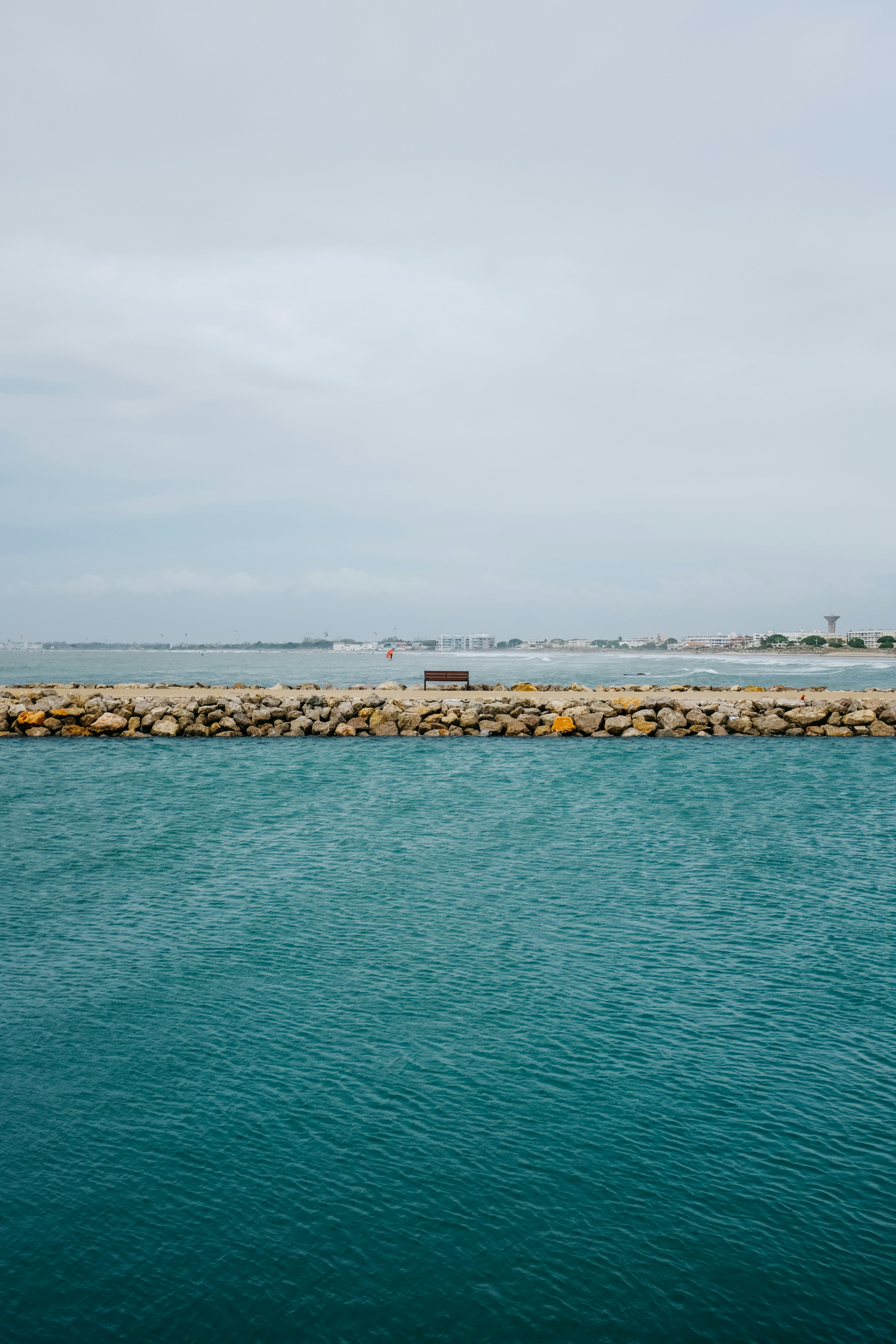 a large body of water next to a stone wall