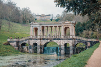 a stone bridge over a river with a building on top of it