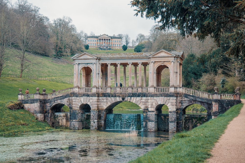 a stone bridge over a river with a building on top of it