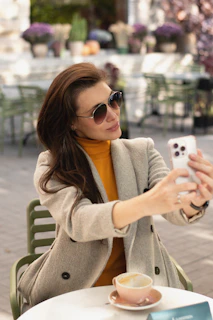 Stylish woman browsing trendy fashion blog on a cozy cafe terrace.