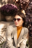 a woman sitting on a bench wearing sunglasses
