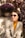 a woman sitting on a bench wearing sunglasses
