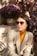 a woman sitting on a bench wearing sunglasses