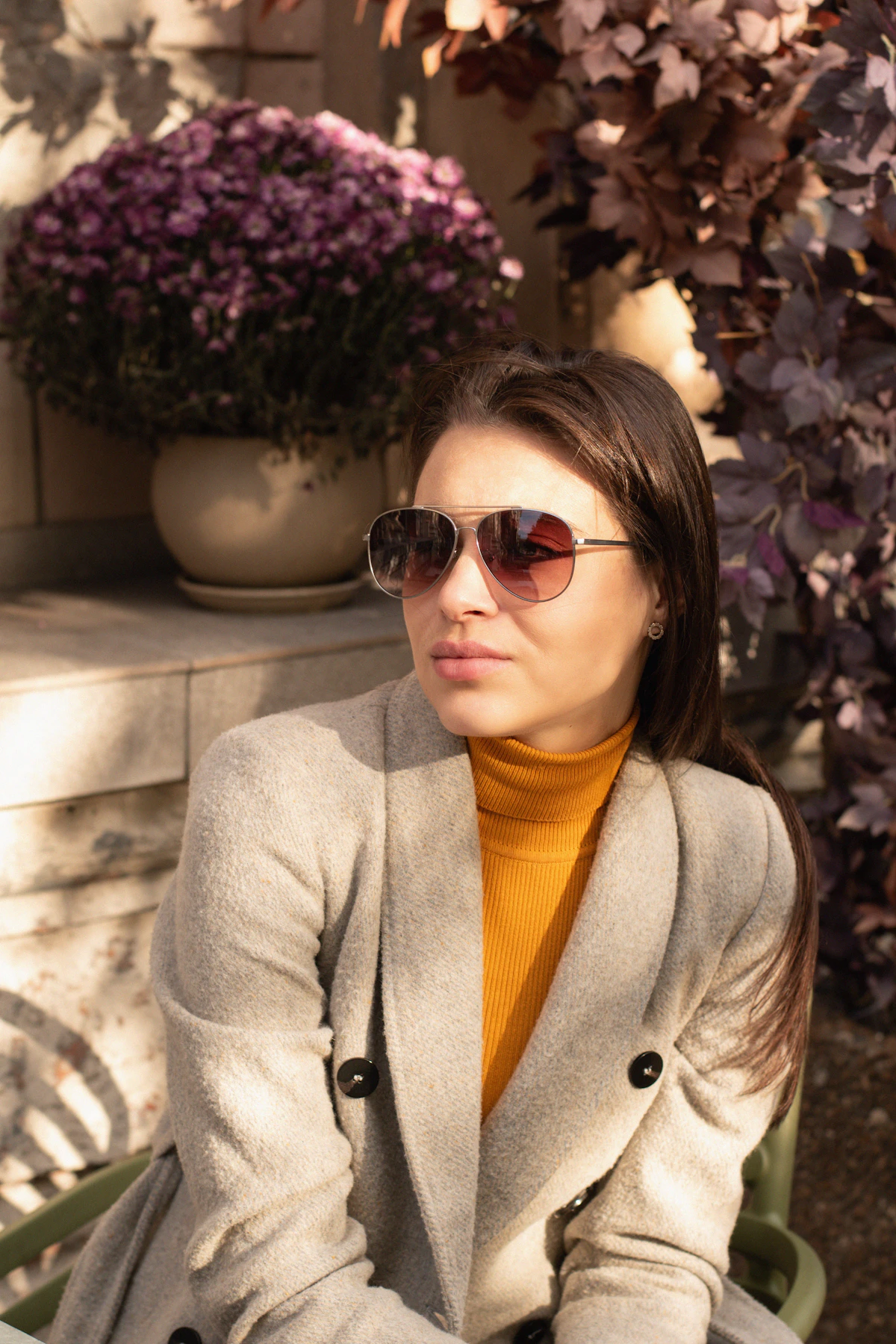 a woman sitting on a bench wearing sunglasses