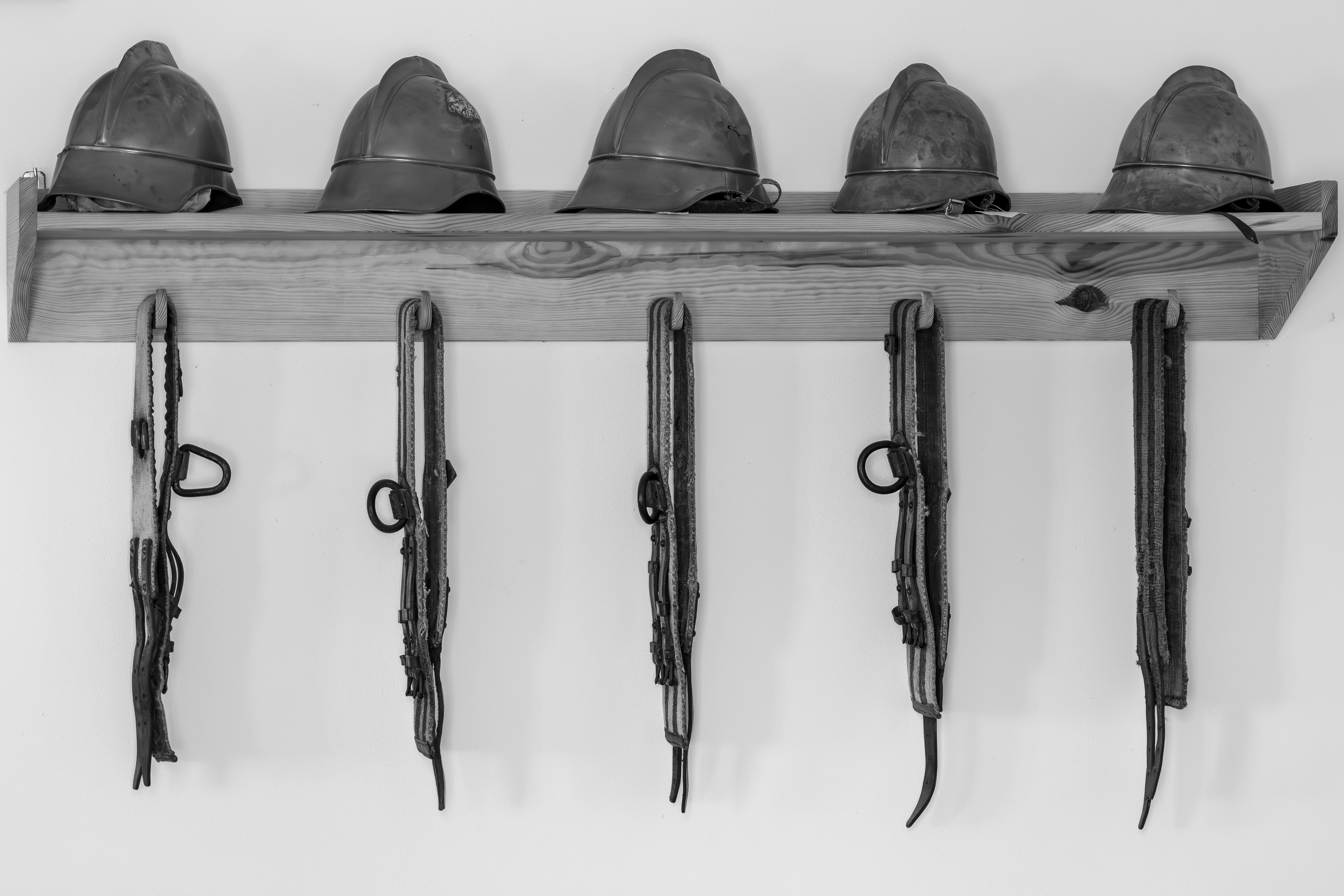 Traditional Polish fire fighter helmets pictured in black and white.