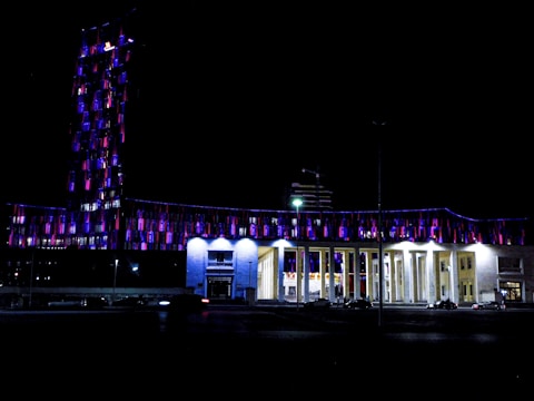 Night shot of a completed building illuminated with dark indigo and maroon accent lights.