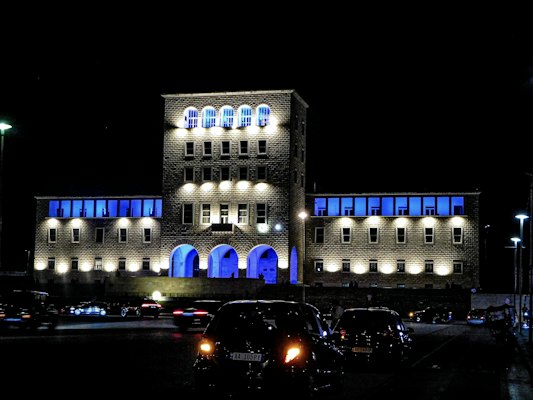 A building lit up with blue lights at night — Tirana, Albania