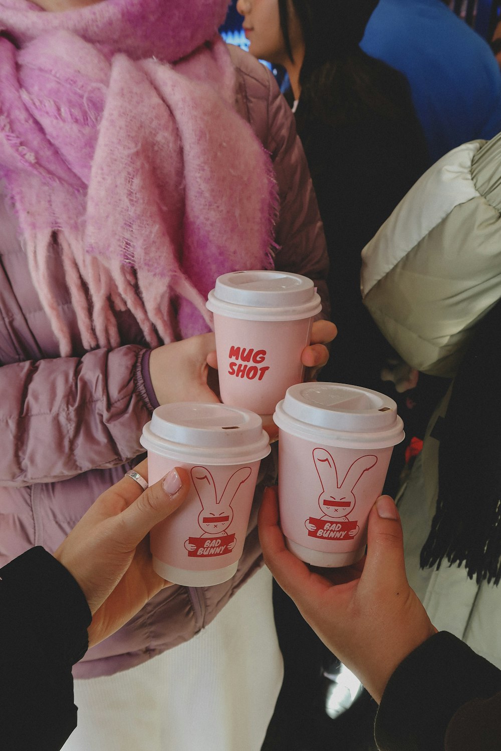 a group of people holding up cups of coffee
