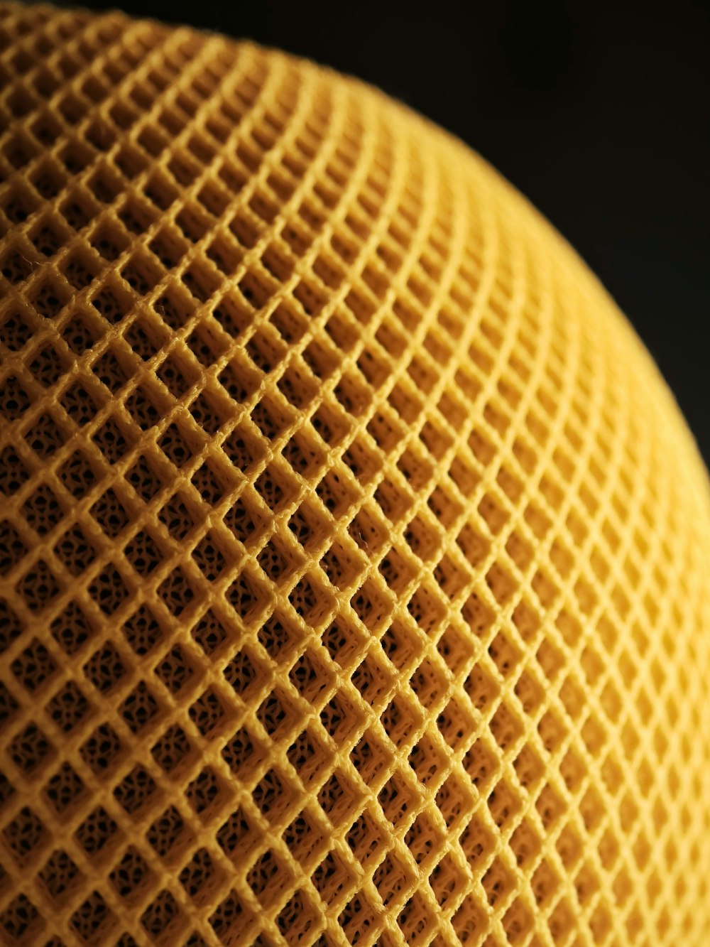 a close up of a yellow object with a black background