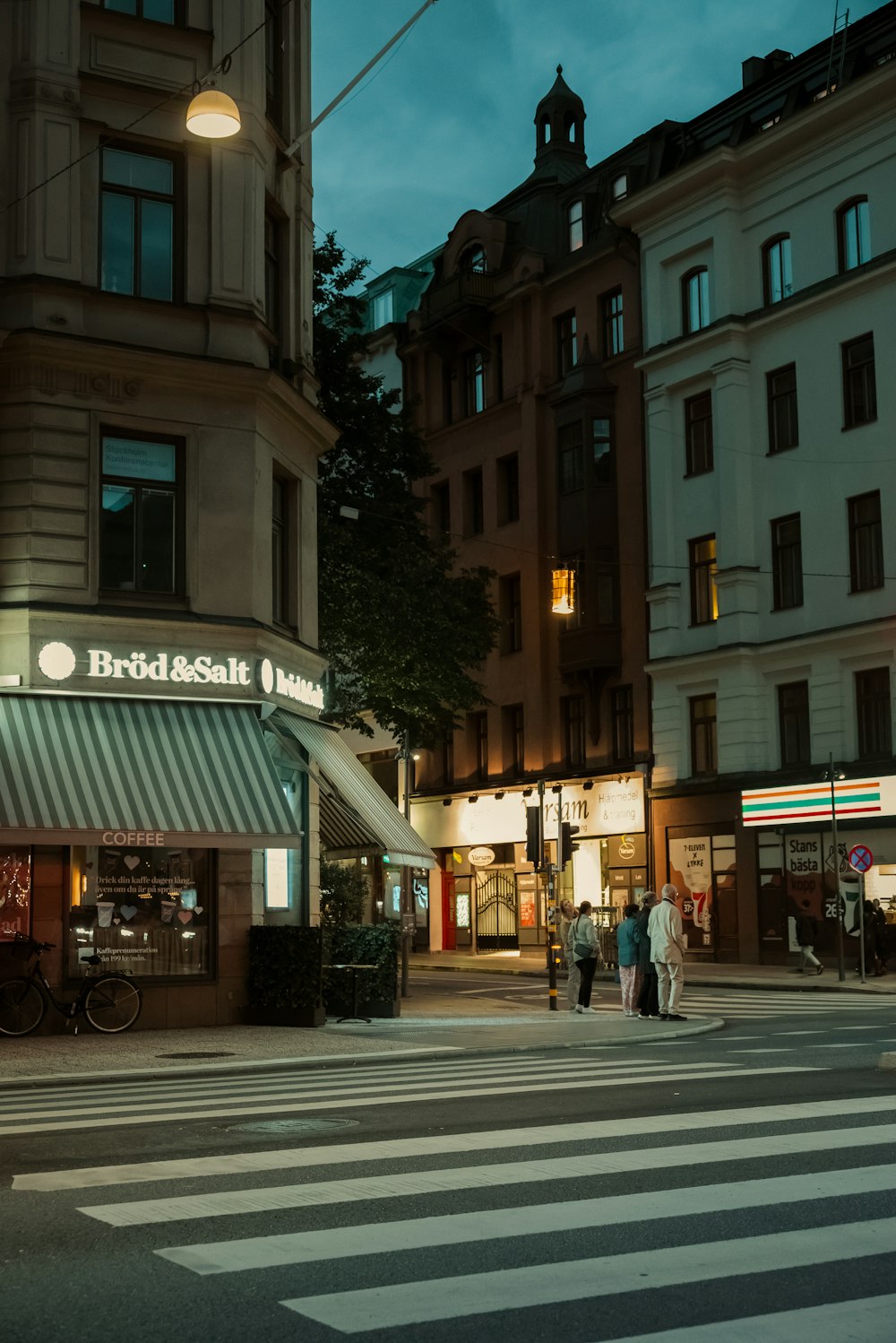 a group of people walking across a street at night