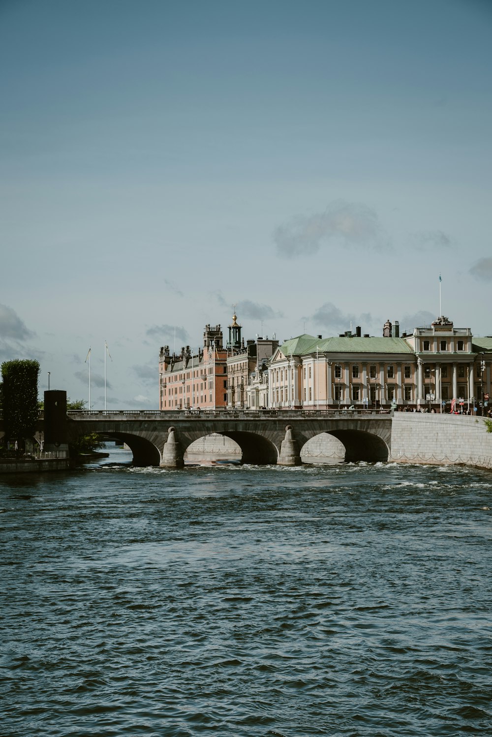 a bridge over a body of water with buildings in the background