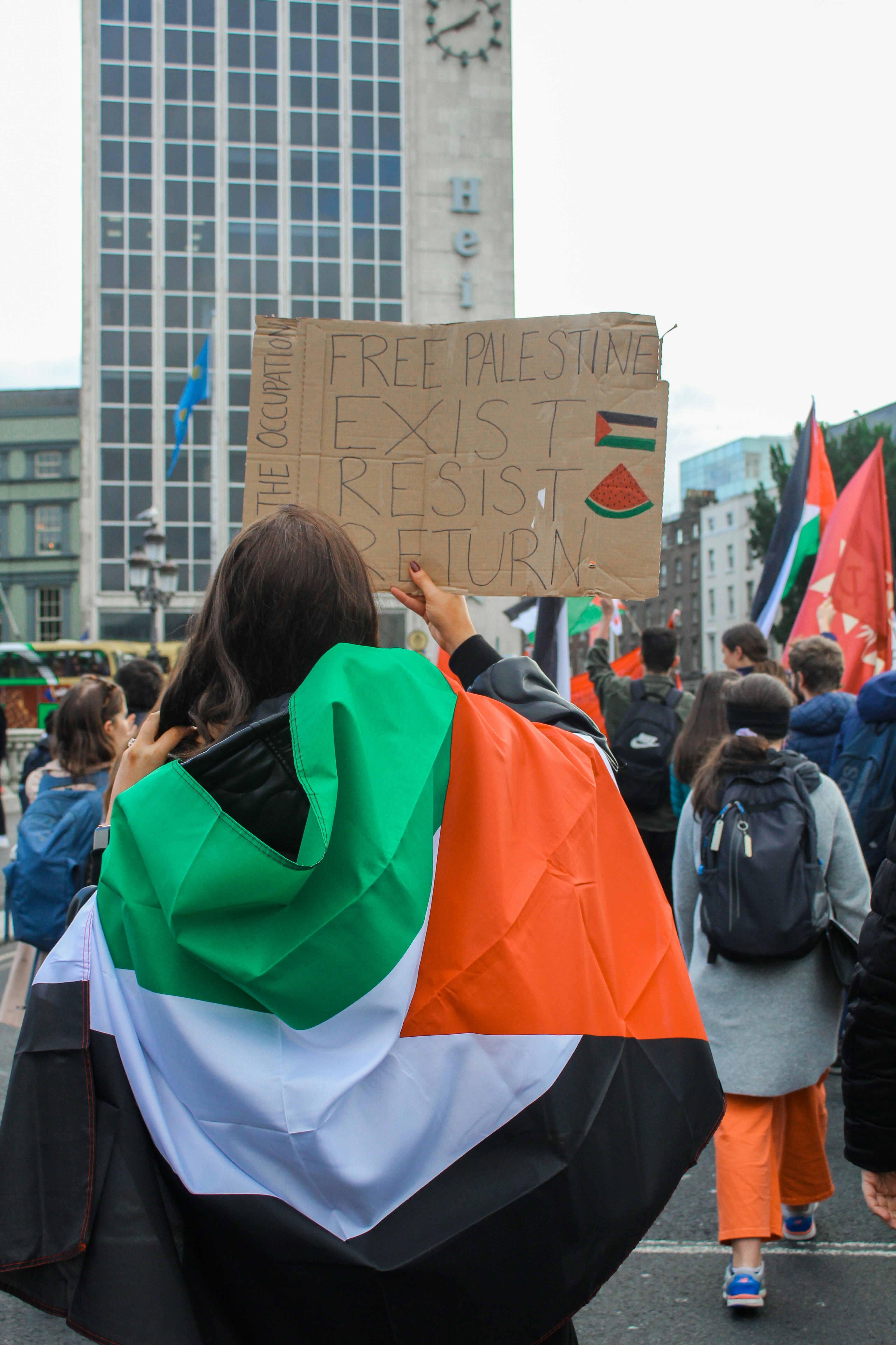a group of people walking down a street holding a sign