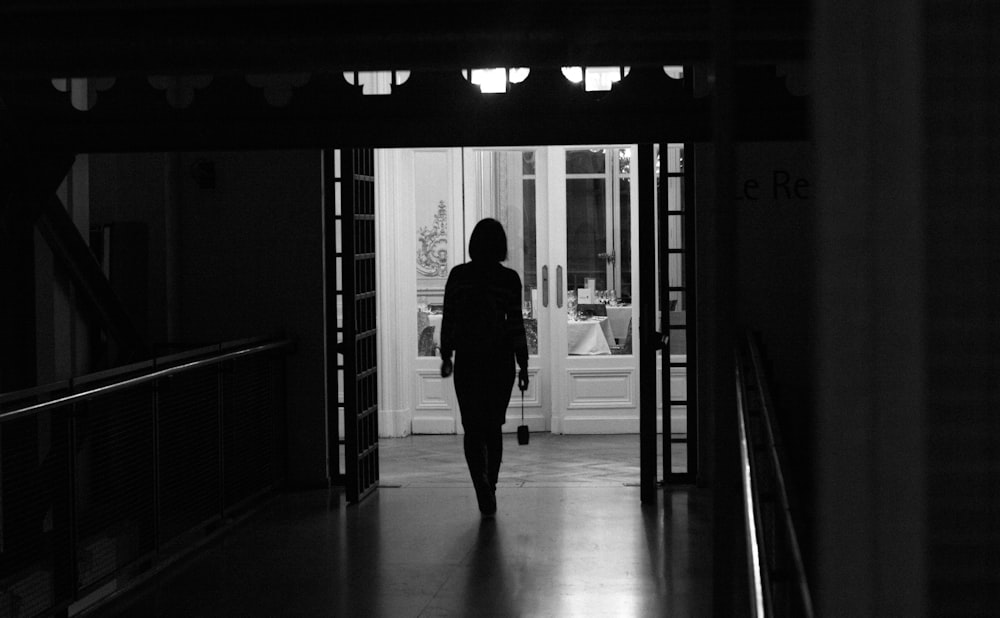 a woman walking down a hallway in a house