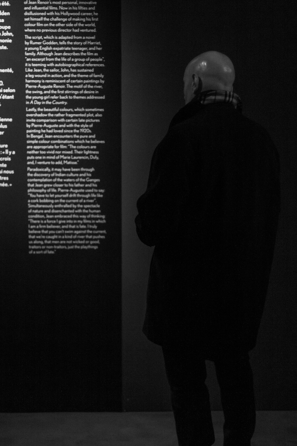 a man standing in front of a black wall