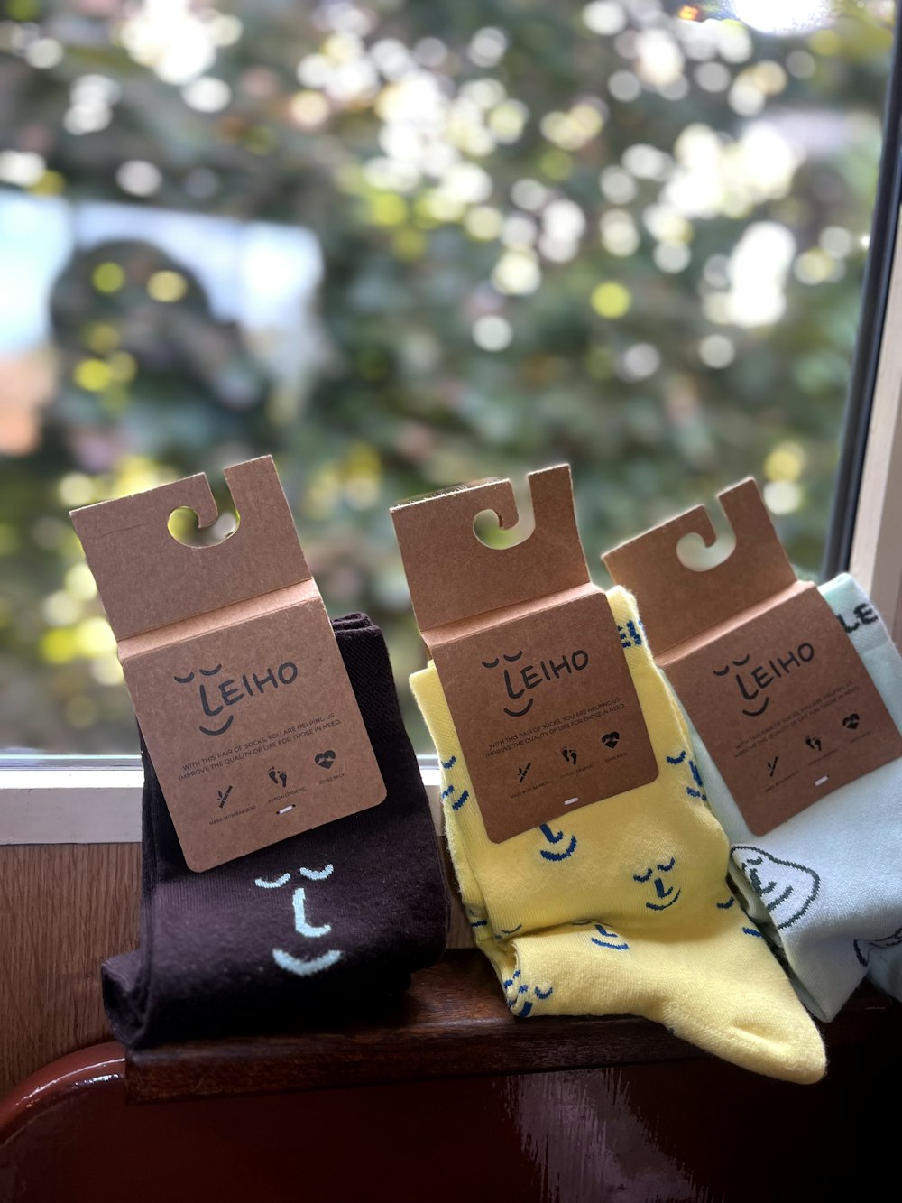 three pairs of socks sitting on top of a window sill