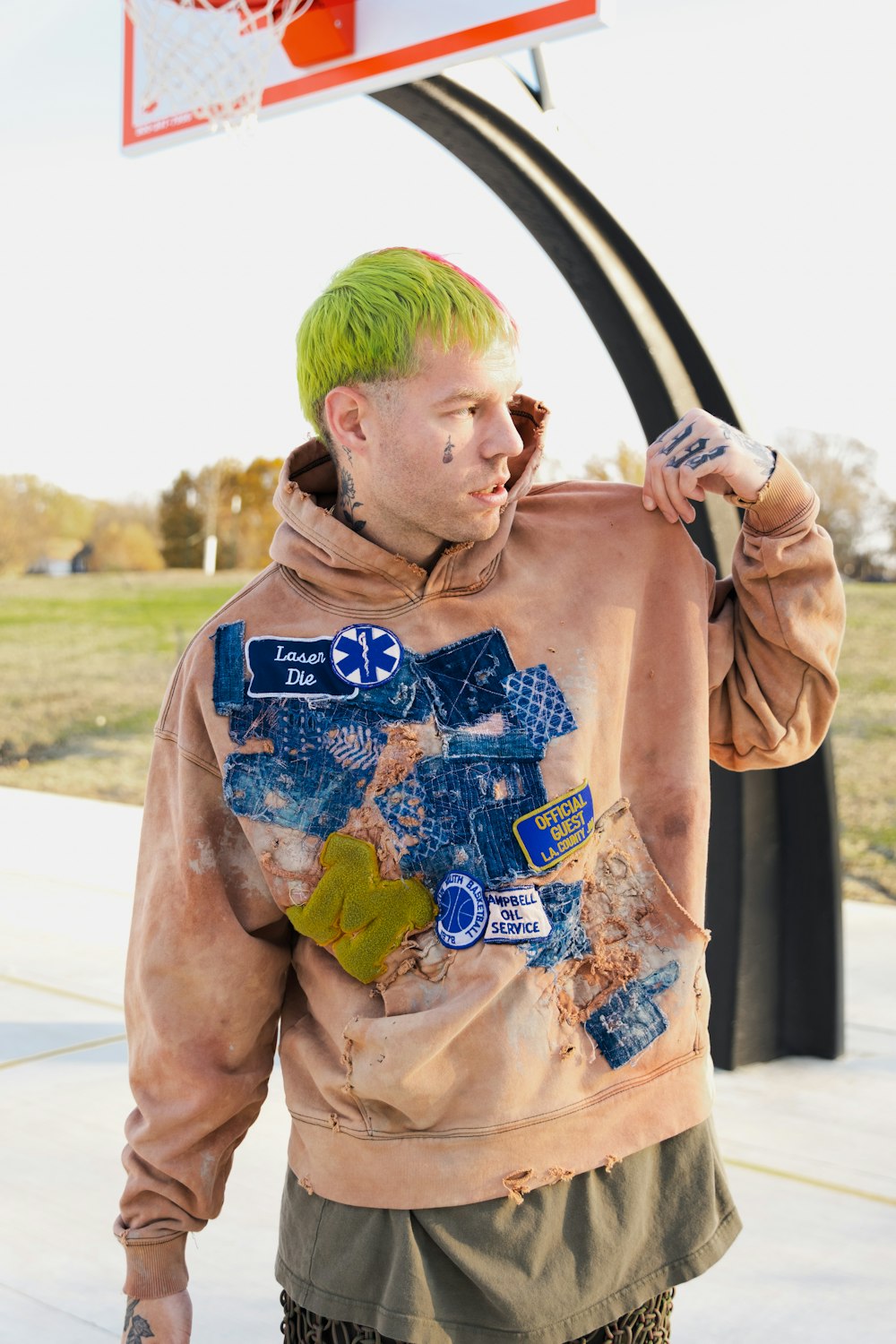 a man with green hair wearing a hoodie