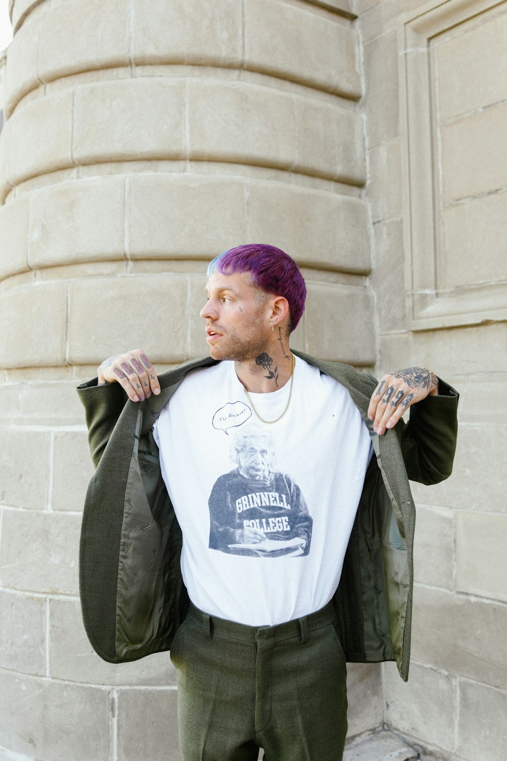 a man with purple hair wearing a white shirt and green pants