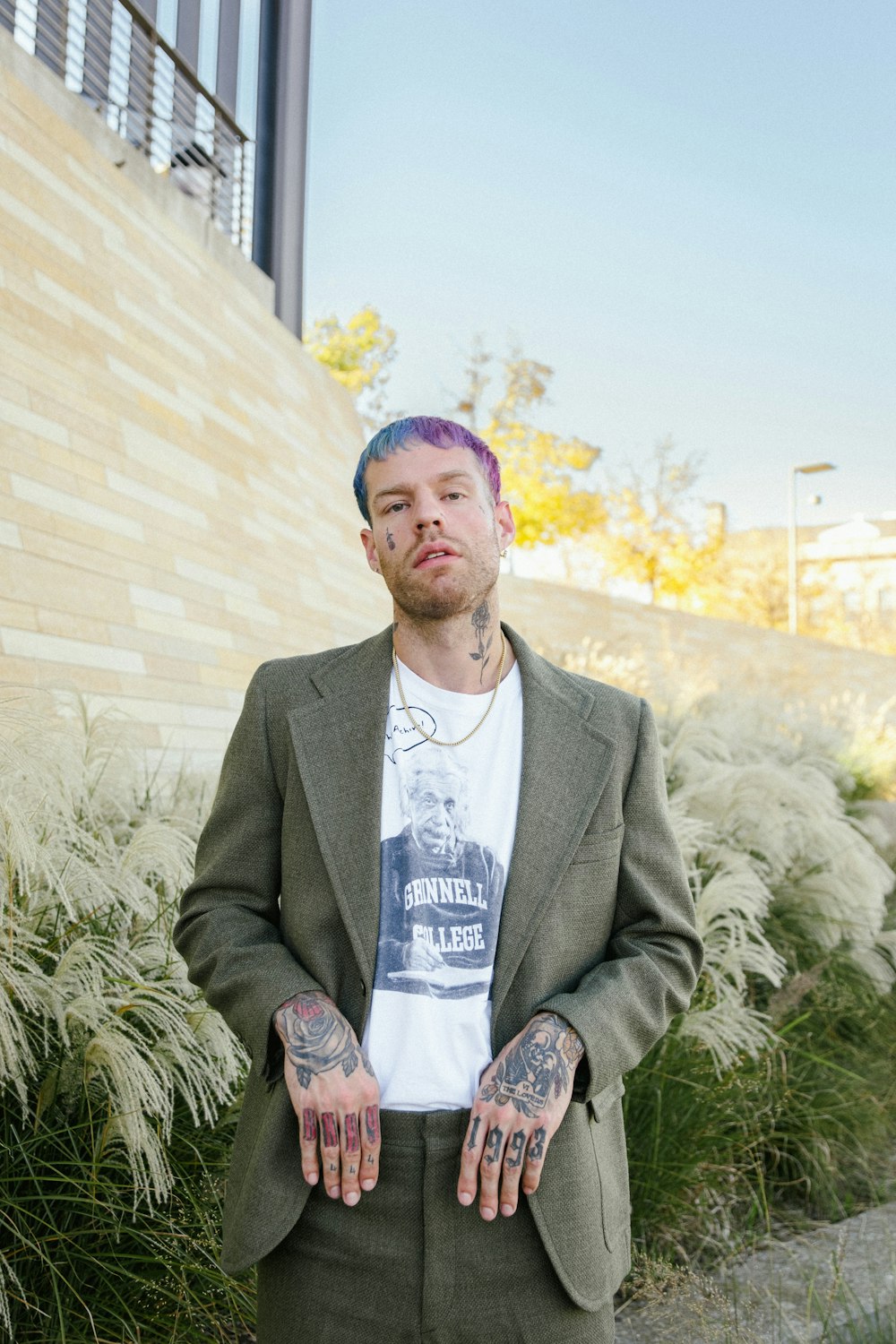 a man with tattoos standing in front of a building