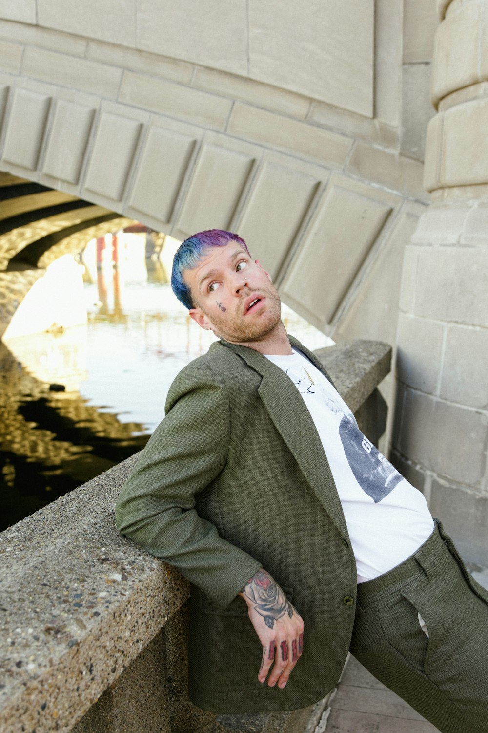 a man in a suit leaning against a wall