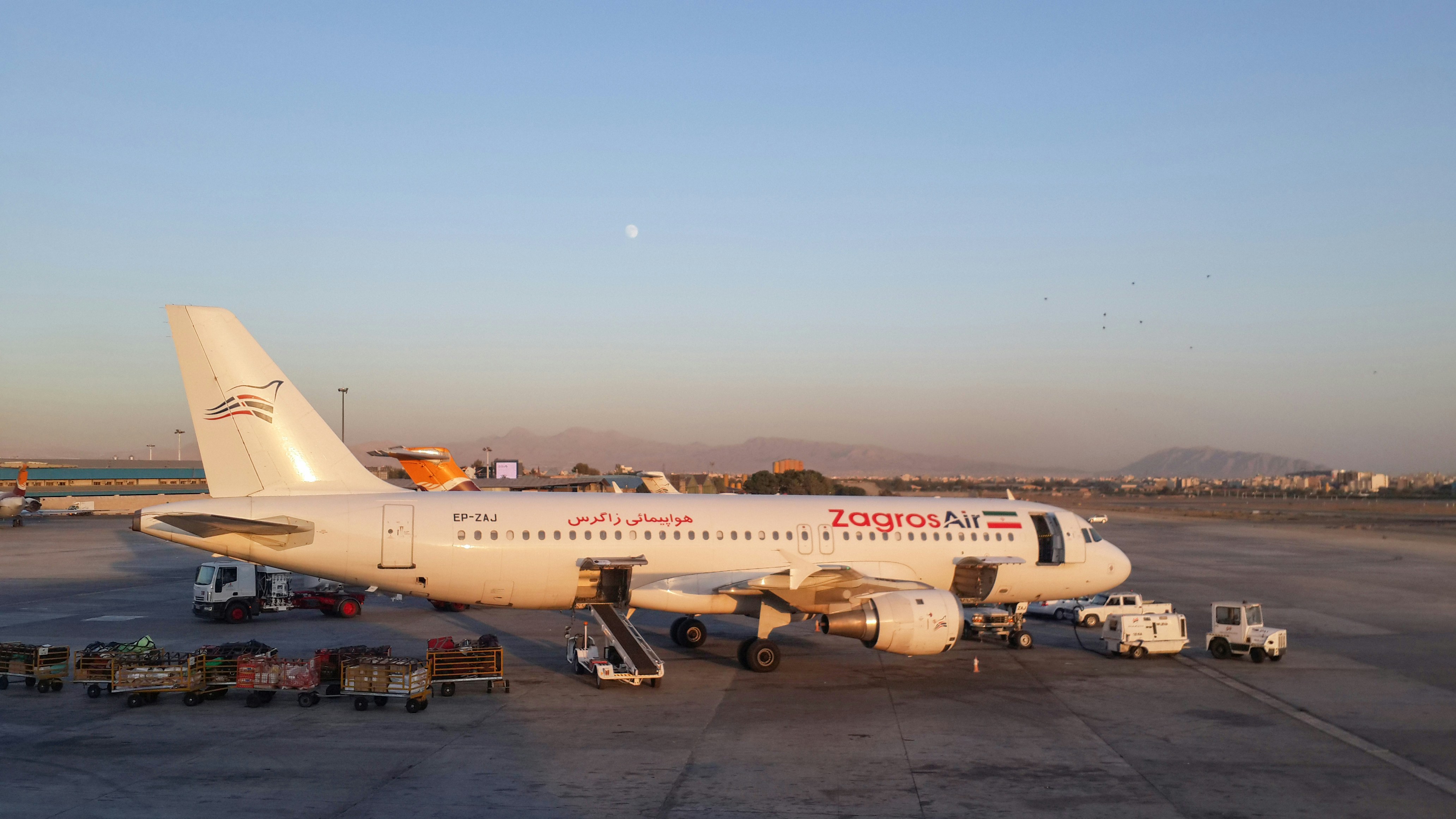 a large jetliner sitting on top of an airport tarmac, zagros air airbus a320 at tehran mehrabad airport, iran