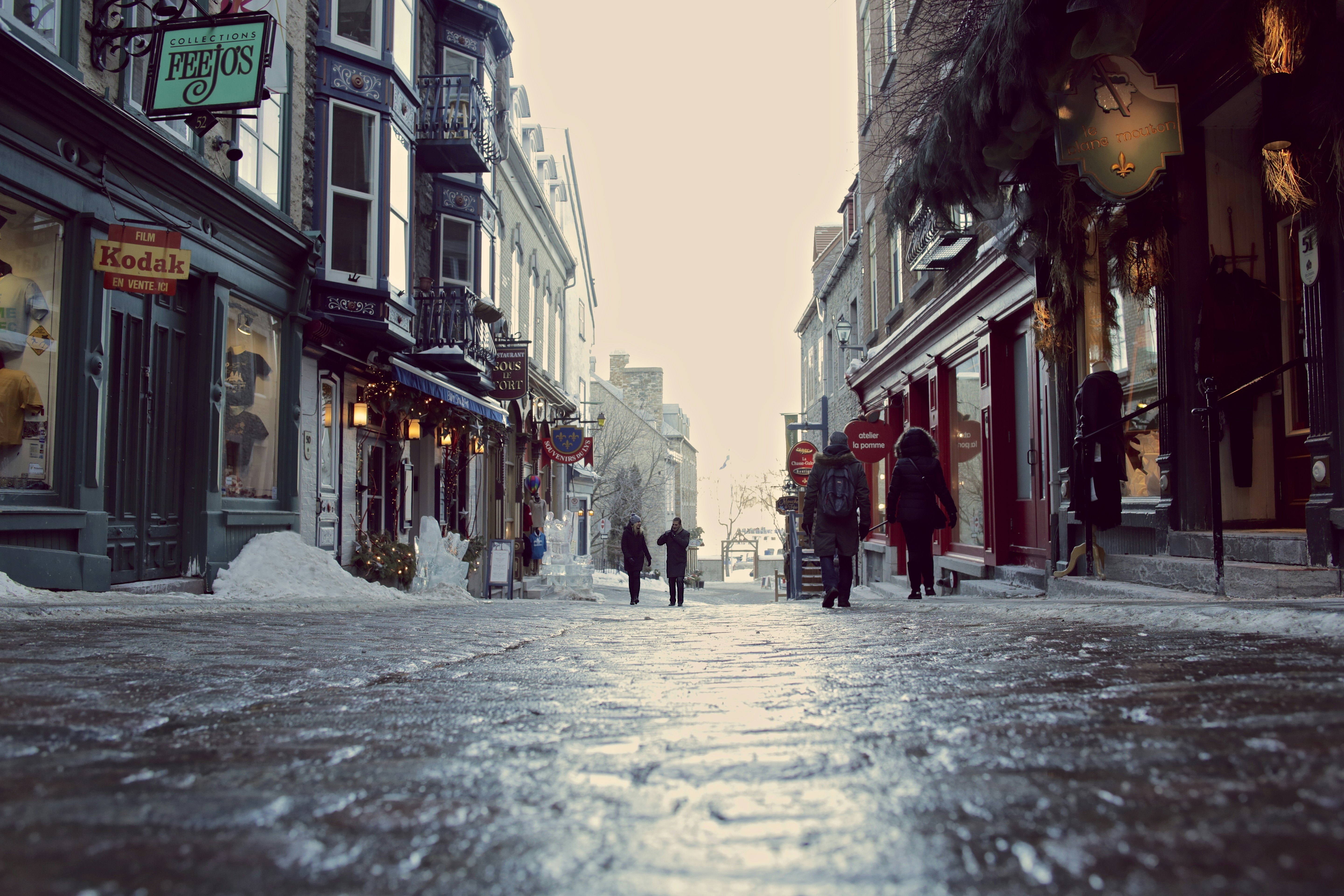 a group of people walking down a snow covered street