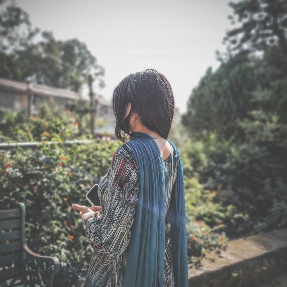 a woman in a kimono standing in a garden