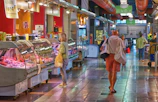 A modern food market interior with sleek displays and customers browsing.