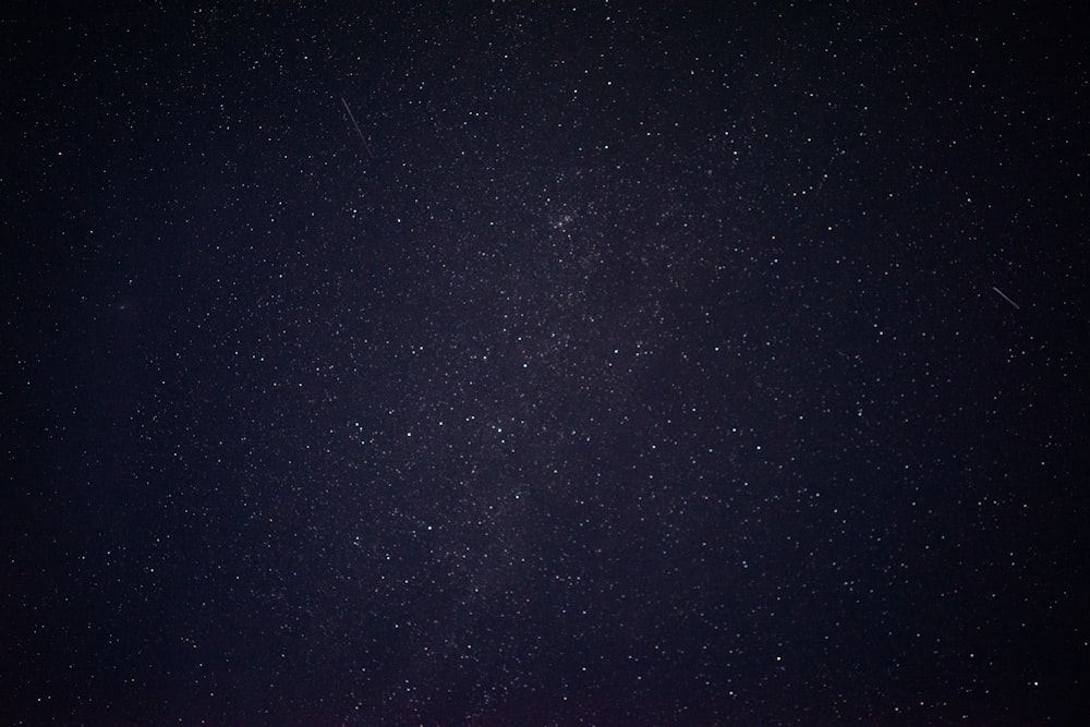 a night sky with stars and a few clouds