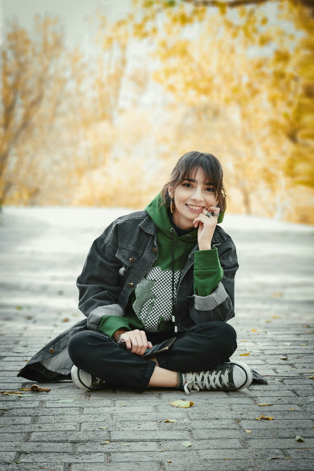 a woman sitting on the ground talking on a cell phone