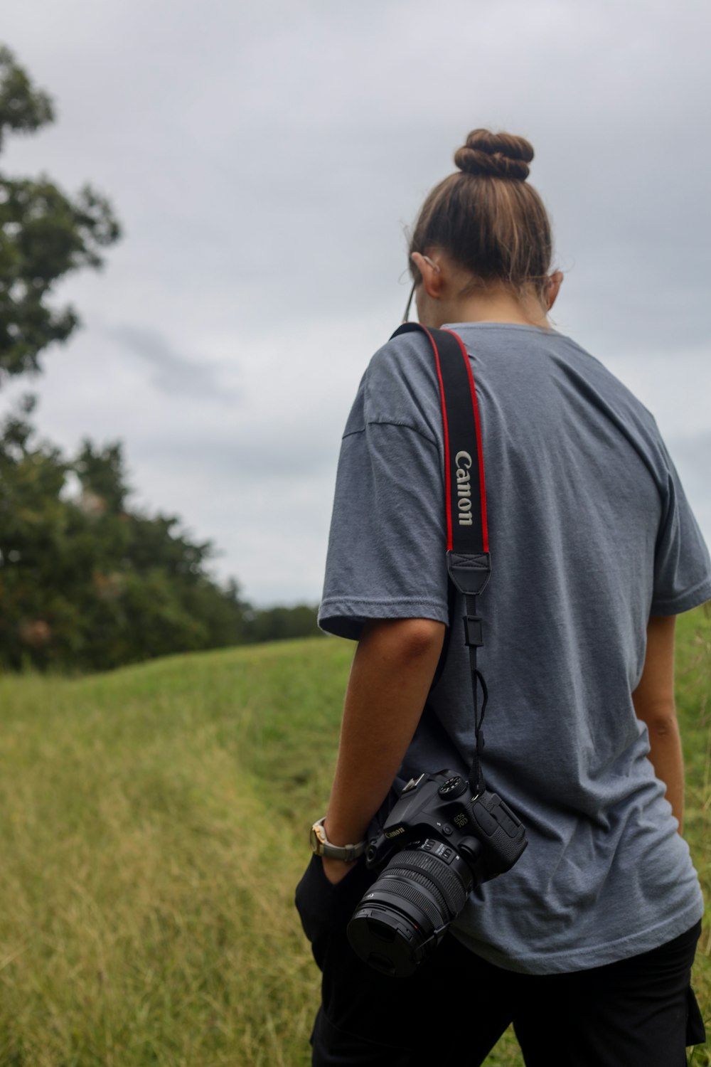 a woman holding a camera in a field