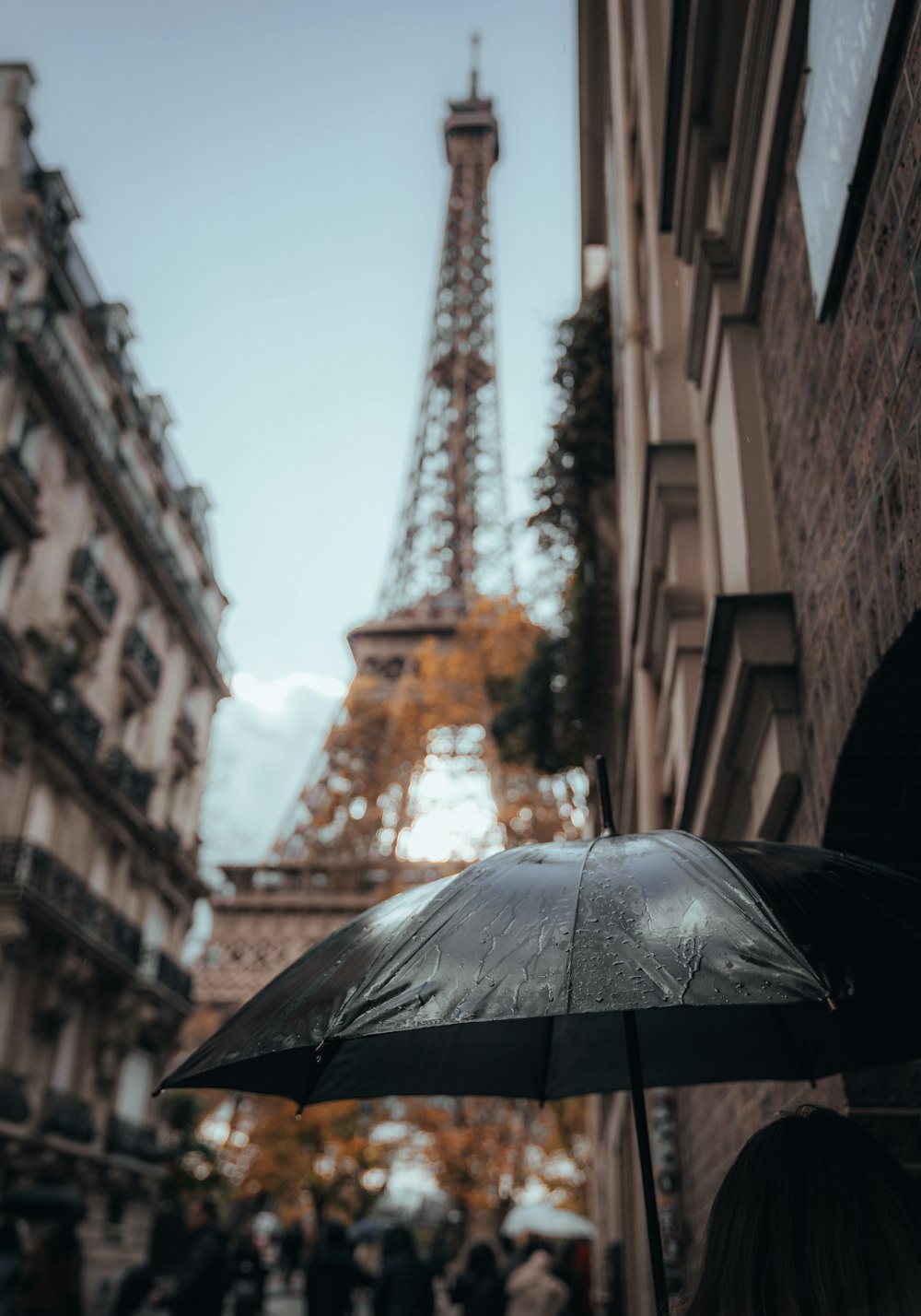 a person holding an umbrella in front of the eiffel tower