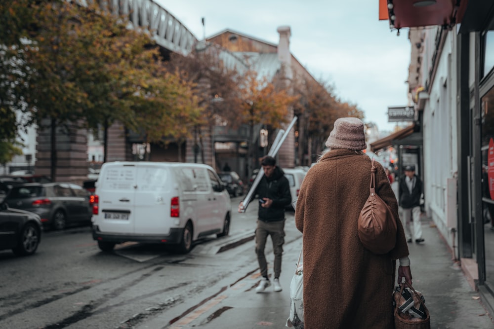 a woman walking down a street next to a white van