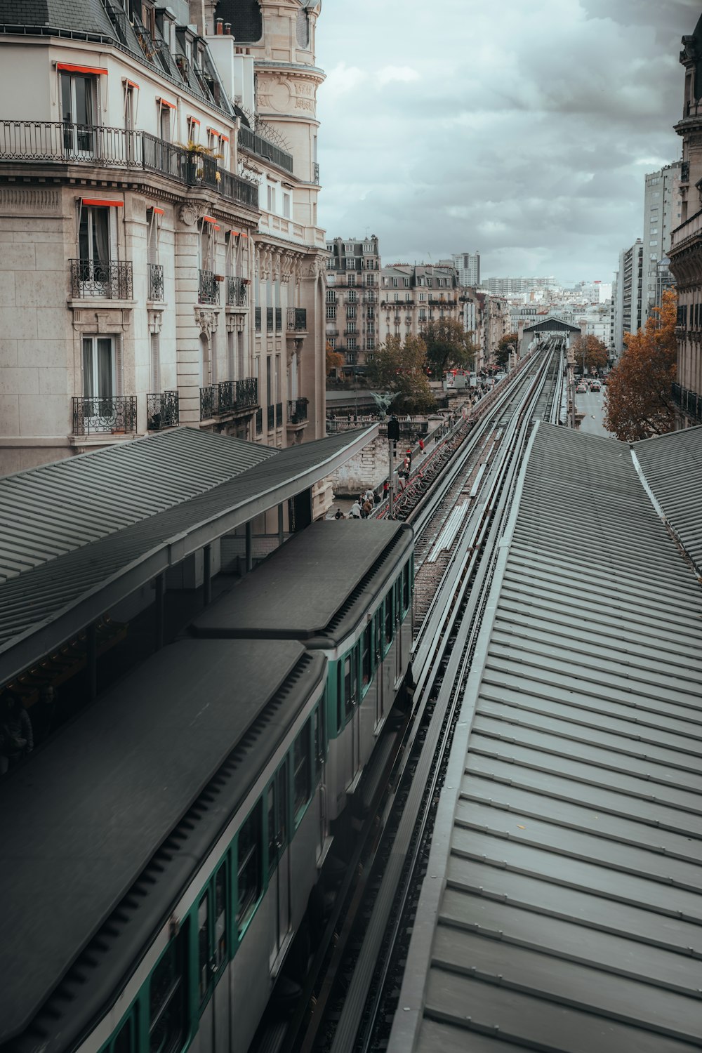 a train traveling down train tracks next to tall buildings