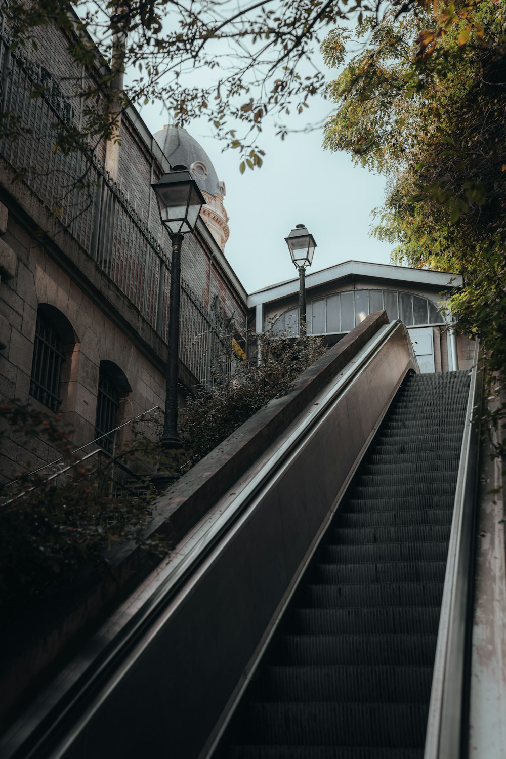 an escalator going down a street next to a building