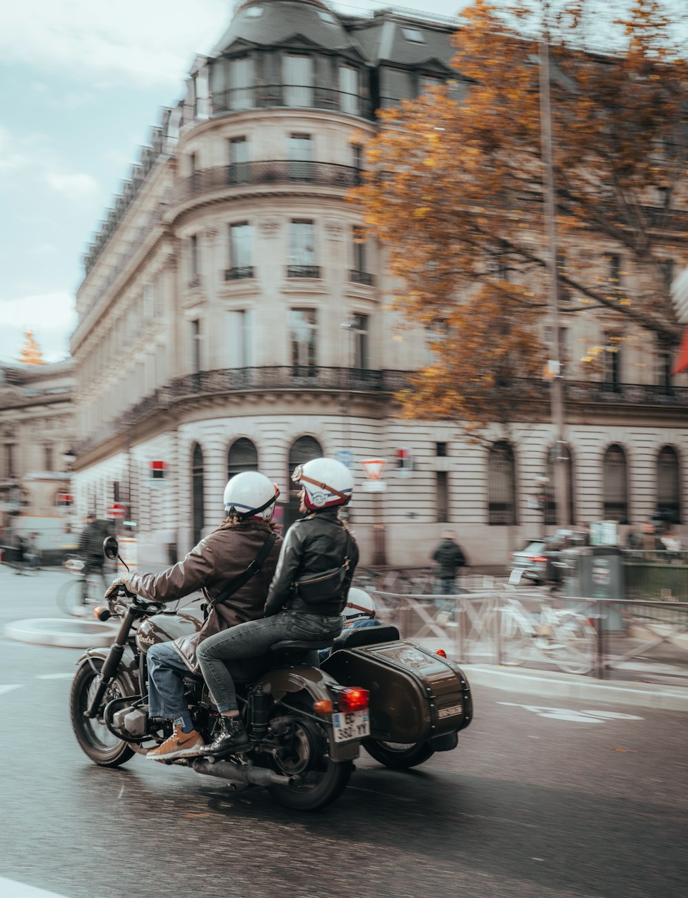 a couple of people riding on the back of a motorcycle